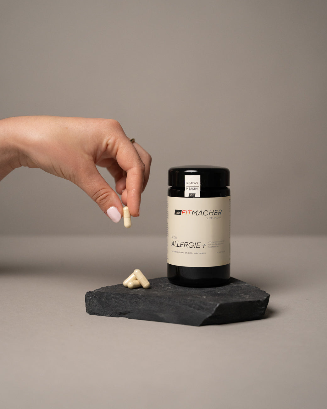 Hand entnimmt eine Kapsel von Allergie+