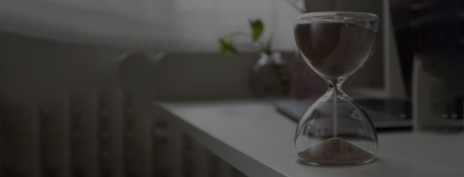 Sanduhr rieselt auf Tisch