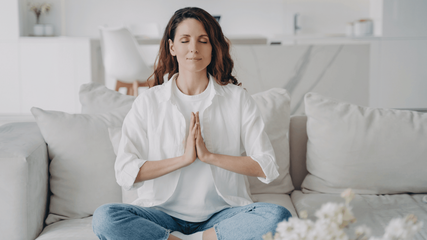 Frau bei Meditation auf Couch
