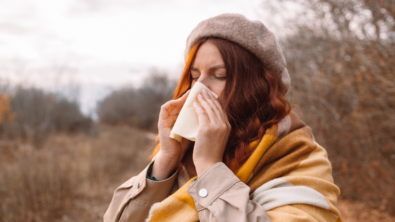 Frau schnäuzt sich die Nase