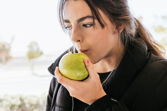 Frau beißt vom Apfel